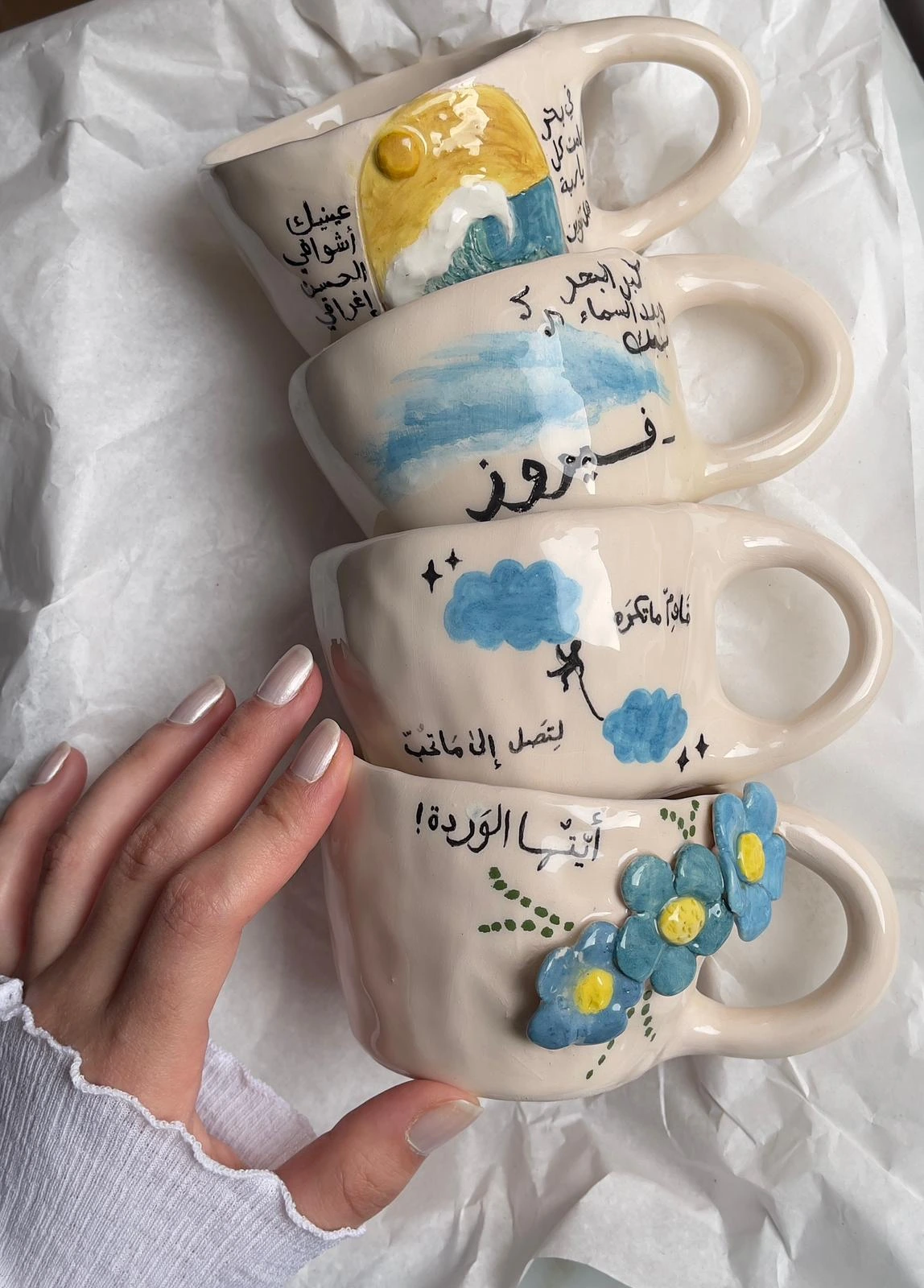 Closeup of hands glazing a handmade ceramic mug in the Duha Ceramic workshop